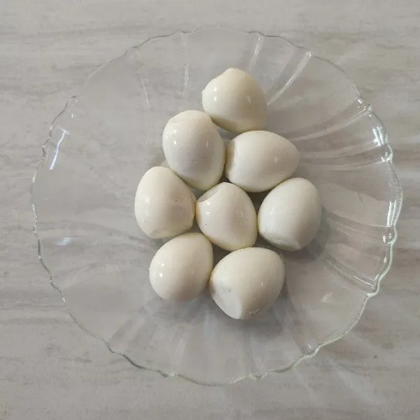 Rebus air hingga mendidih, masukkan telur puyuh. Masak hingga matang, angkat dan kupas kulitnya.