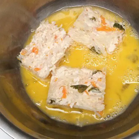 Angkat adonan kukus. Diamkan hingga dingin. Keluarkan dari loyang, kemudian potong-potong. Celup ke dalam telur kocok. Balur hingga rata.