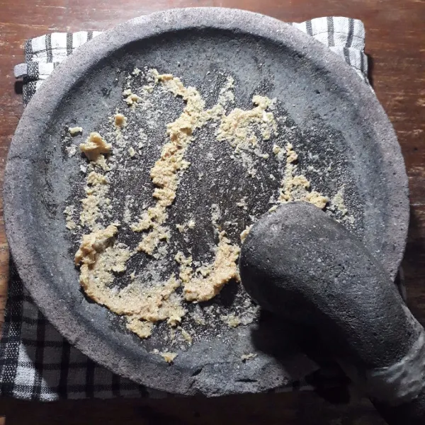 Uleg halus bawang putih, ketumbar dan kemiri.
