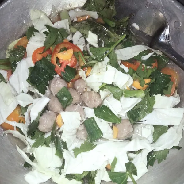 Masukkan air, sayuran, dan bakso.