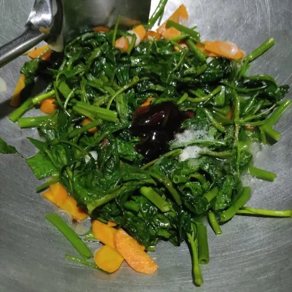 Setelah kangkung layu, tambahkan air, garam, kaldu bubuk dan saos tiram, aduk rata.