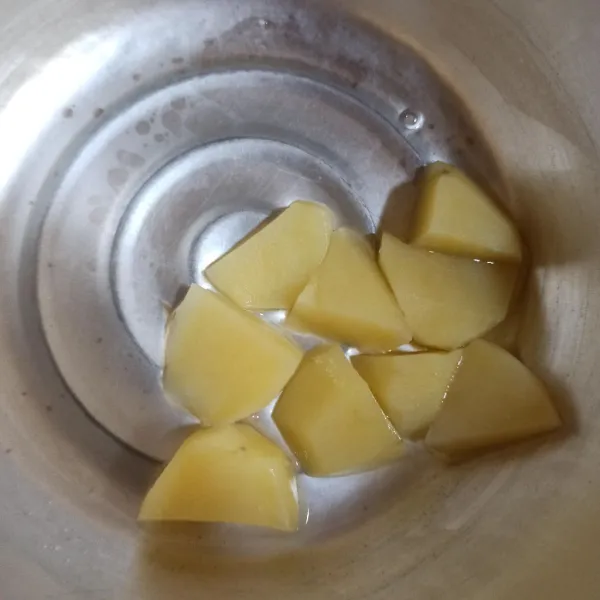 Didihkan 250 ml air. Rebus kentang hingga empuk.