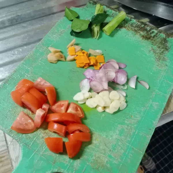 Iris tipis bawang merah, bawang putih, lengkuas, kunyit dan tomat.