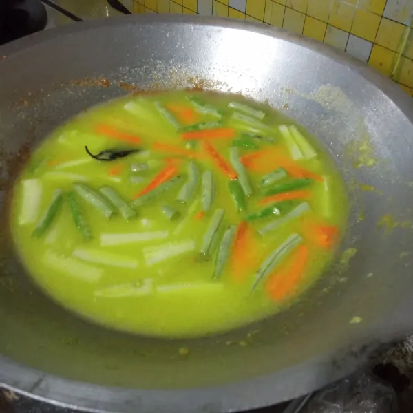 Tambahkan air, masukkan sayur. Masak hingga mendidih.
