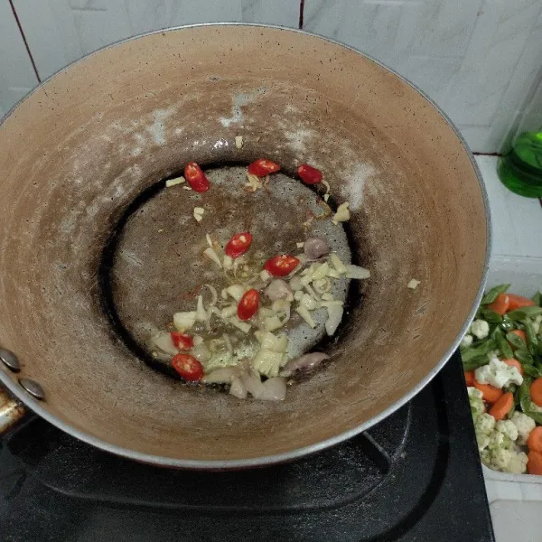 Panaskan minyak lalu tumis bawang merah dan bawang putih hingga harum lalu masukkan cabe merah iris.