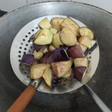 Potong-potong terong, cuci bersih lalu goreng hingga berkulit, angkat dan tiriskan.