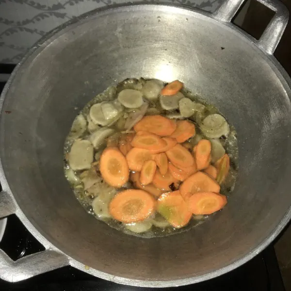 Tambahkan air, lalu masukkan wortel, tunggu sampai wortel setengah matang