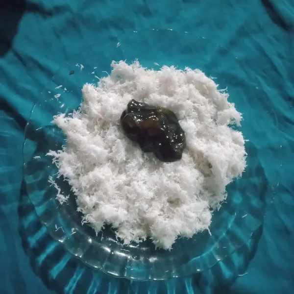 Baluri potongan kue dengan kelapa parut hingga rata, sajikan.