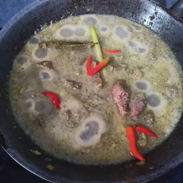 Beri air hingga daging terendam, tunggu mendidih. Masukkan santan, kecap gula, garam, dan kaldu bubuk. Tes rasanya. Lalu masukkan 5 buah cabe rawit.
