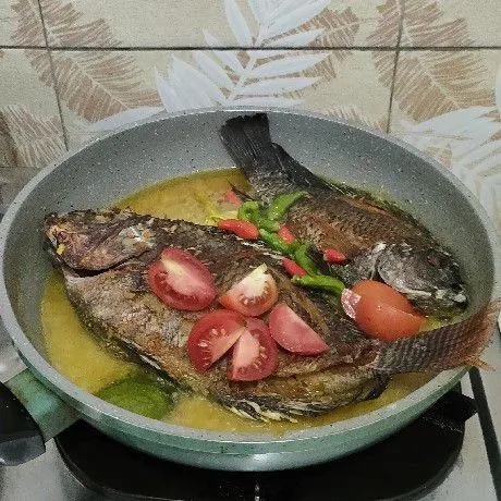 Balik ikan pelan-pelan. Masukkan tomat dan cabe rawit