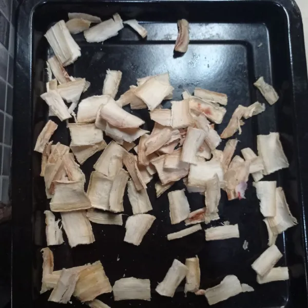Iris tipis singkong yang sudah dikukus, tata pada wadah kemudian jemur hingga kering.