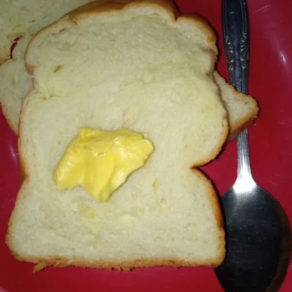 Ambil 1 lembar roti tawar kemudian oles salah satu sisinya dengan margarin. Tumpuk satu lembar roti di atasnya.