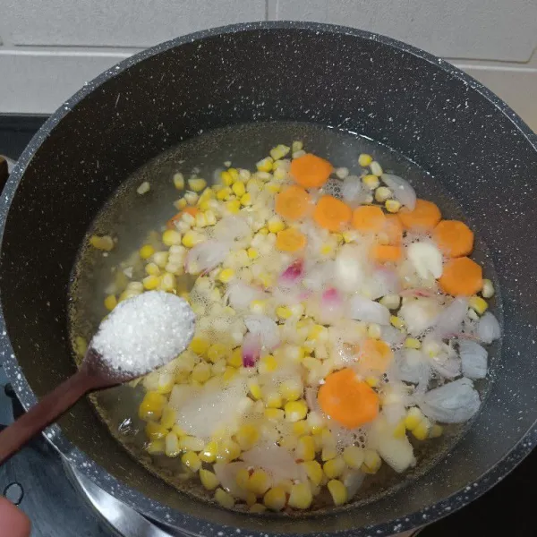 Bubuhi gula garam kaldu bubuk. Dan rebus hingga jagung dan wortel empuk atau mendidih lagi.
