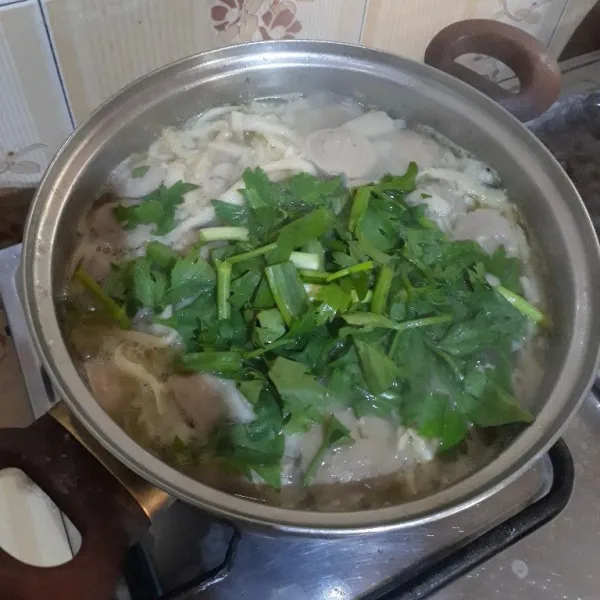 Setelah mendidih, masukkan daun bawang dan seledri. Aduk sebentar lalu matikan kompor. Sajikan sup jamur tiram bakso selagi hangat.
