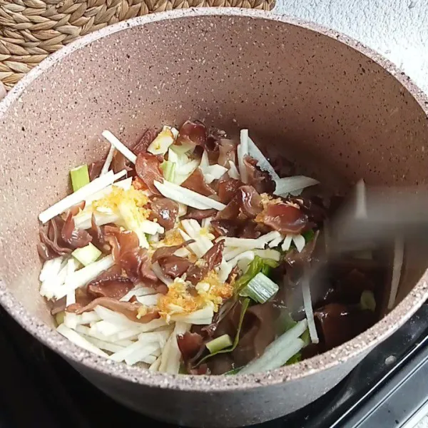 Masukkan irisan bengkoang, jamur kuping, daun bawang dan bunga sedap malam. Aduk hingga layu.