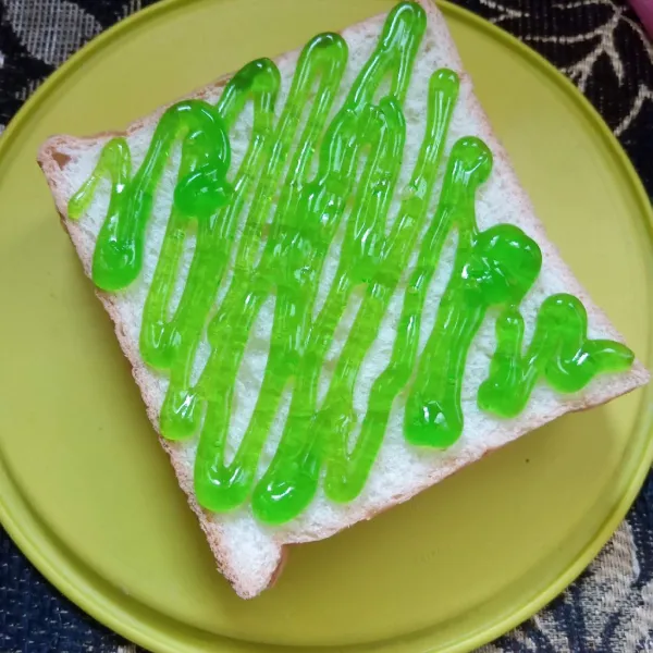 Tutup dengan selembar roti tawar, beri selai melon.