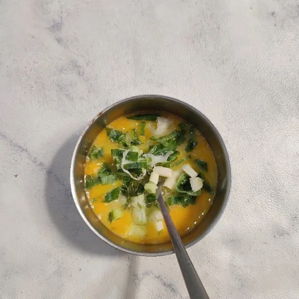 Kocok lepas telur bersama kaldu hubuk dan merica, lalu masukkan daun bawang, aduk rata.