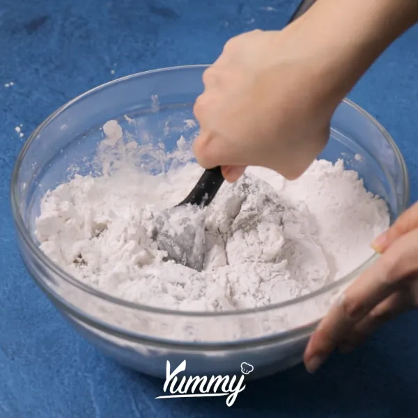 Pindahkan dalam mangkuk dan tambahkan 125 gr tepung tapioka, aduk dengan spatula hingga tercampur rata dan kalis.