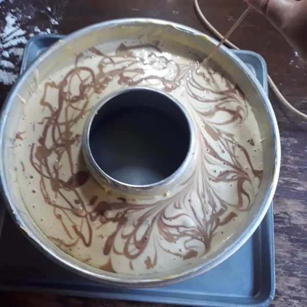 Olesi loyang tulban diameter 26 cm dengan margarin. Tuang adonan putih - cokelat - putih - moka, lakukan hingga adonan habis. Tarik dengan tusuk sate untuk membuat motif.