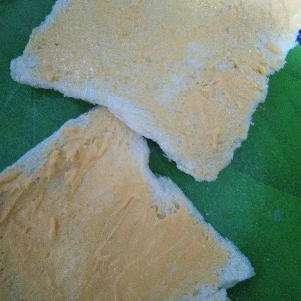 Oles permukaan roti dengan mayonaise.