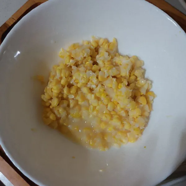 Tumbuk atau ulek sebagian jagung pipil. Lalu campur dengan jagung pipil utuh dalam mangkuk.