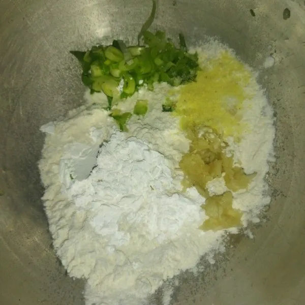 Siapkan wadah. Masukkan tepung terigu, tepung tapioka, bawang putih halus, daun bawang, garam, dan kaldu bubuk.