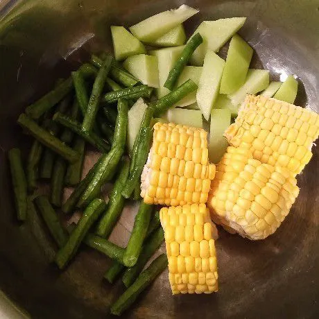 Siapkan bahan utamanya. Potong-potong jagung manis, kacang panjang, dan labu siam. Kemudian cuci sampai bersih.