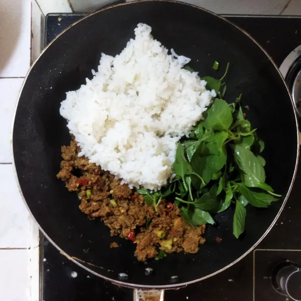 Dalam wadah campur oncom, nasi panas dan kemangi. Aduk hingga merata.