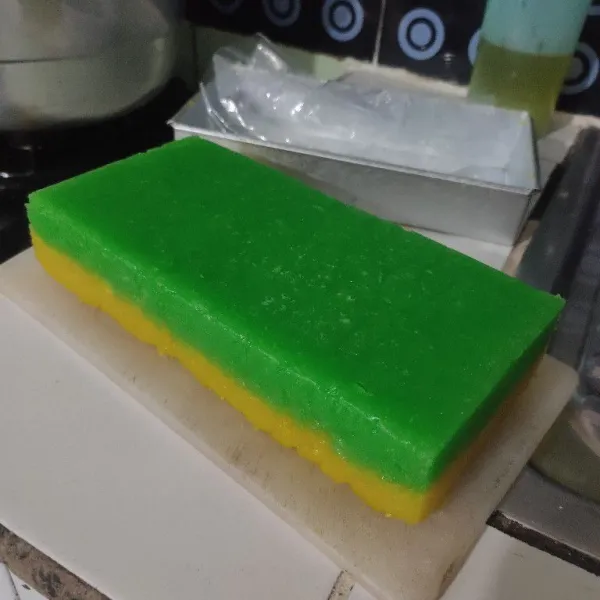 Setelah hangat keluarkan dari loyang, potong-potong lalu gulingkan di atas kelapa parut.