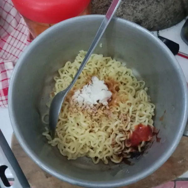 Mie yang sudah direbus angkat tiriskan tambahkan bumbu mie instan aduk rata.