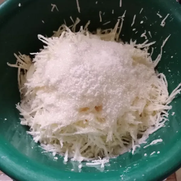 Parut singkong memanjang. Kemudian masukkan gula pasir, garam dan vanili. Aduk rata.