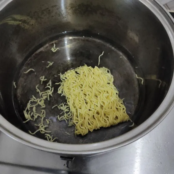 Rebus 1 keping mie kuning hingga setengah matang lalu angkat dan tiriskan.