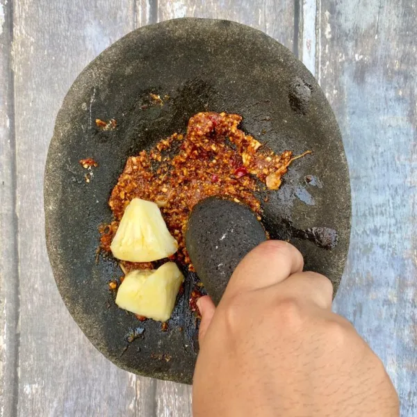 Ulek cabai, garam, gula merah dan kacang tanah. Lalu tambahkan 2 iris nanas dan pala bubuk, ulek kembali.