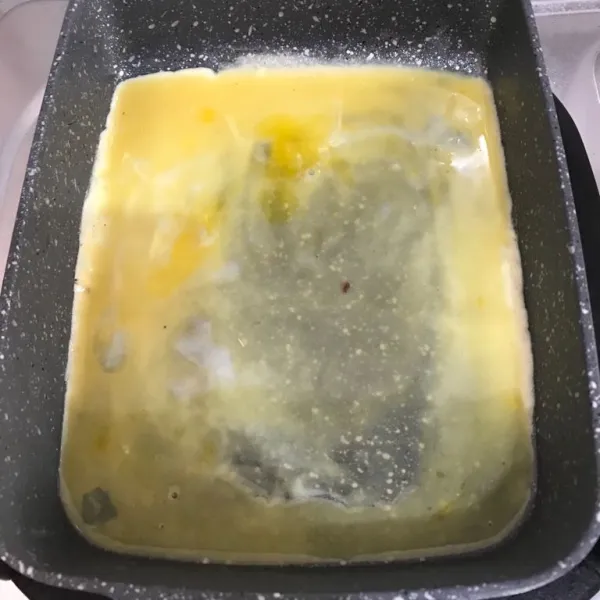 Dalam wadah kocok lepas telur yang diberu susu, garam, kaldu bubuk, dan lada, tuang setengah bagian ke dalam teflon, masak hingga kedua sisi matang.