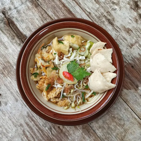 Beri kuah, potongan seledri dan kerupuk.