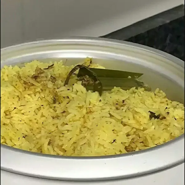 Pertama masukkan nasi kedalam wadah lalu beri bumbu aduk nasi kuning aduk rata.