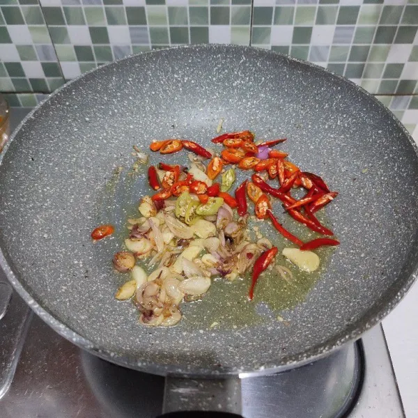 Masukkan cabe rawit dan cabe keriting. Tumis hingga layu.