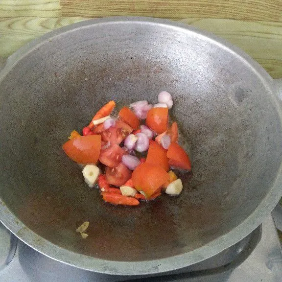 Goreng tomat, cabe, bawang merah, dan bawang putih hingga layu.
