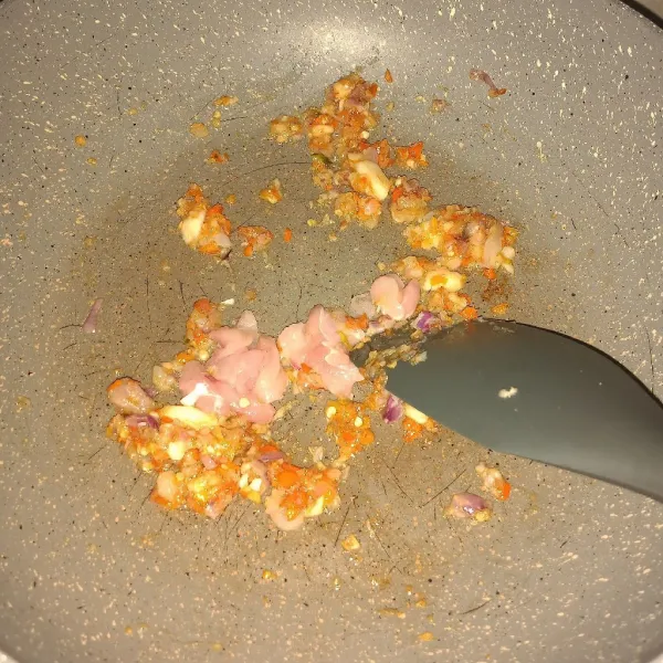 Panaskan sedikit minyak, tumis bawang merah, bawang putih, dan cabe rawit cincang sampai wangi. Tambahkan potongan daging ayam, masak sampai berubah warna.