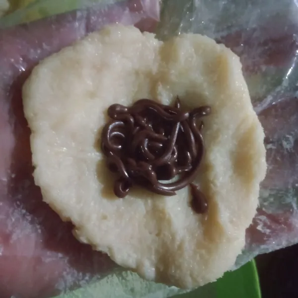 Ambil 1 sendok makan adonan tape, pipihkan. Isi dengan selai.