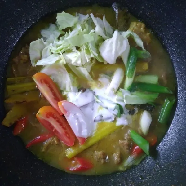 Terakhir masukkan kol, daun bawang, tomat, dan santan. Aduk, masak sebentar saja sampai semua bahan tercampur.