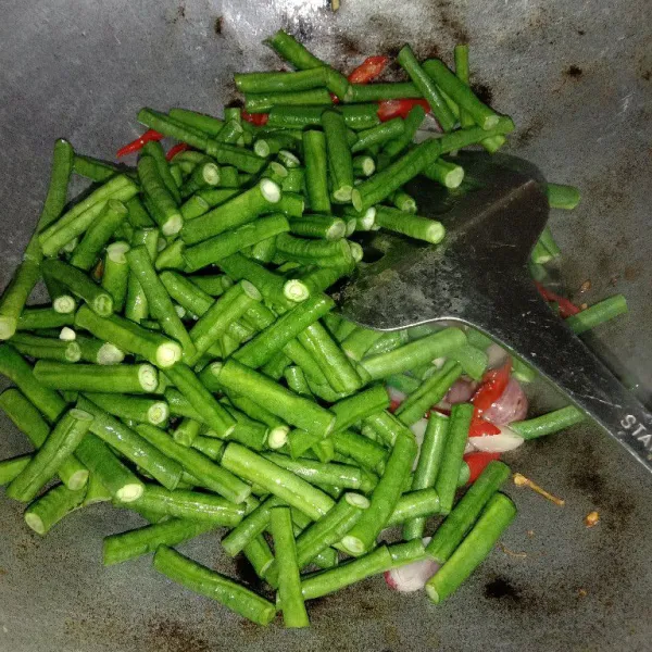 Masukkan kacang panjang yang sudah dicuci bersih, aduk-aduk sampai berubah warna.
