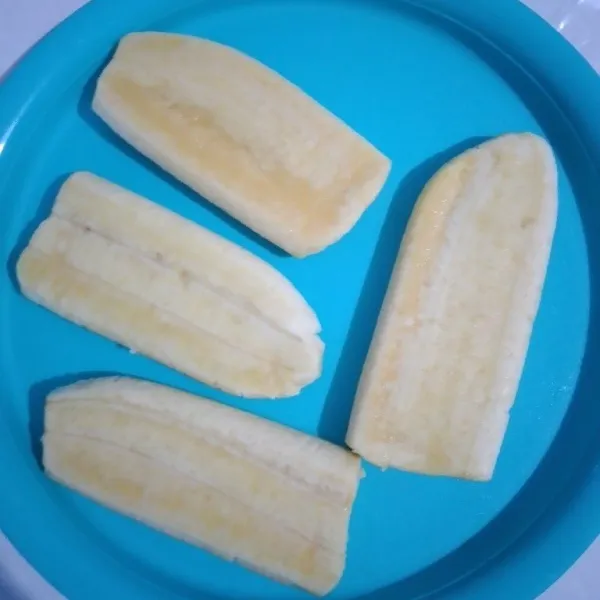 Potong pisang menjadi 2 bagian, pipihkan.