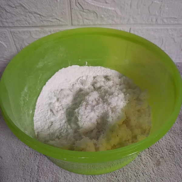 Masukkan kelapa parut. Jika kelapa parut terlalu kering, tambahkan sedikit air. Selanjutnya aduk sampai berbentuk pasir.
