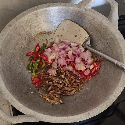 Masukkan irisan bawang dan cabe, masak aduk rata dulu.