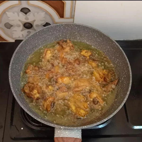 Angkat ayam ungkep, panaskan minyak, lalu goreng hingga setengah matang. Masukkan duo bawang dan cabe, aduk rata sampai layu.