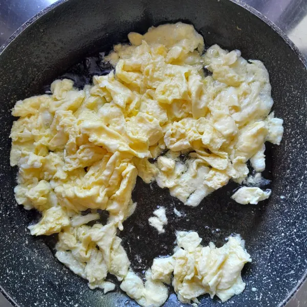 Panaskan secukupnya minyak dalam wajan, kemudian masukkan kocokan telur. Orak-arik telur, angkat dan sisihkan terlebih dahulu.