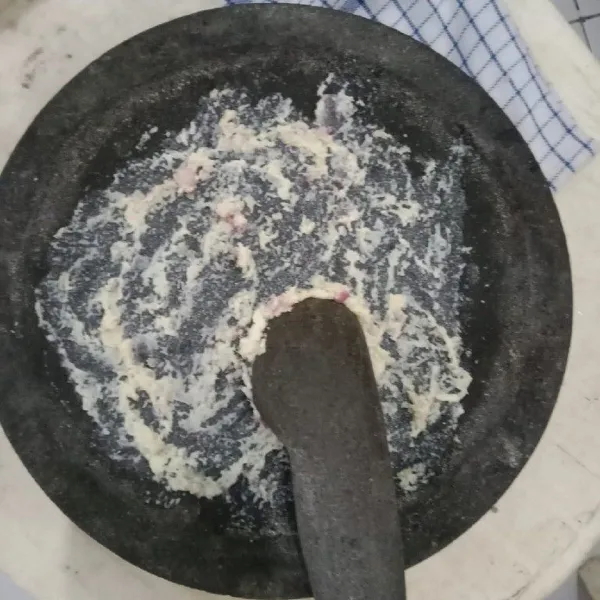 Ulek halus bawang merah, bawang putih, kemiri, dan lengkuas.
