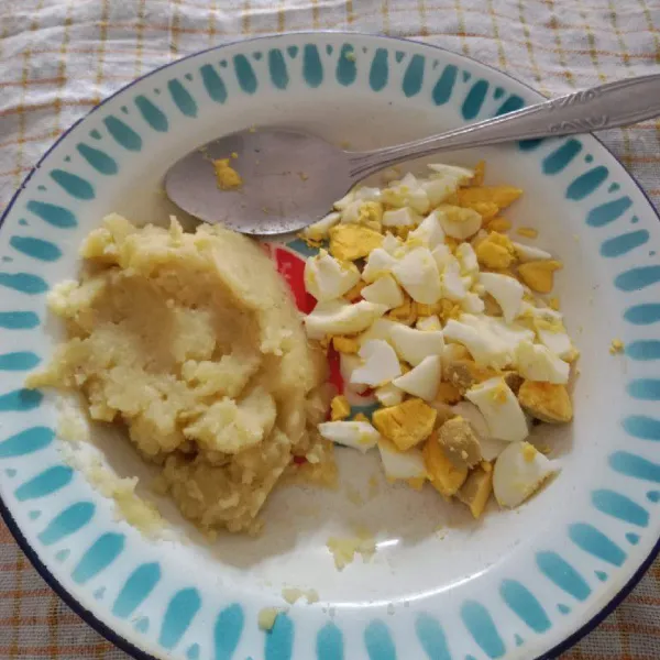 Tumbuk kentang hingga hancur kemudian beri garam, merica dan penyedap rasa, aduk rata, cincang telur rebus dan taburi garam.