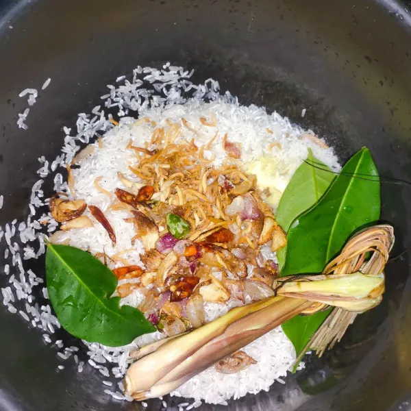 Cuci beras dan masukkan teri goreng, bumbu iris goreng, dan rempah.